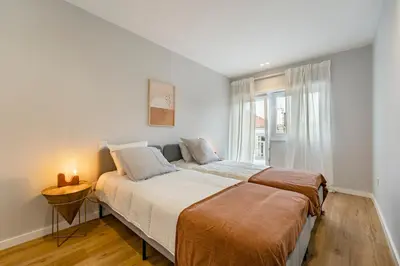 a white bedroom with a bed and a window at Nomad's Sunny Firmeza - 2BED Porto in Porto