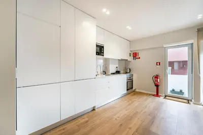a kitchen with white cabinets and a hardwood floor at Nomad's Sunny Firmeza - 2BED Porto in Porto