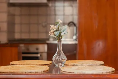 a glass vase with flowers in it on a table at Ribeira Cozy Apartment in Porto