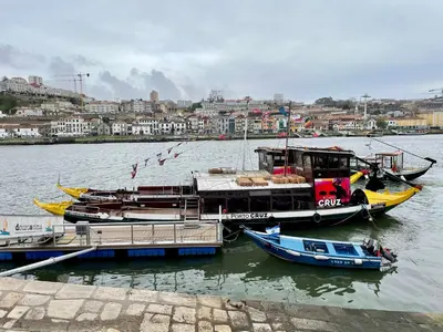 three boats are docked at a dock in the water at Ribeira Cozy Apartment in Porto