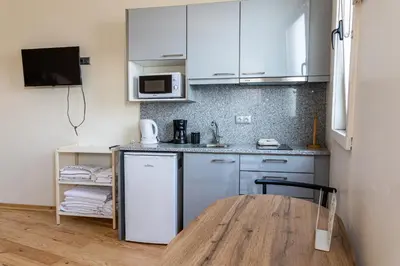 a kitchen with white cabinets and a wooden table at House on a rustic Island At Campanha Trainstation in Porto