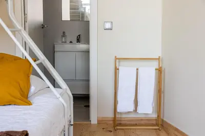 a bedroom with a mirror next to a bed at House on a rustic Island At Campanha Trainstation in Porto