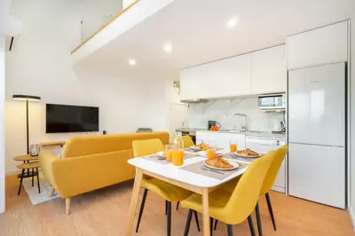 a kitchen and dining room with a table and yellow chairs at WHome Riverside View Premium Apartment w/ AC & Terrace in Porto