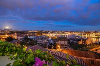 a city at night with a river and buildings at WHome Riverside View Premium Apartment w/ AC & Terrace in Porto