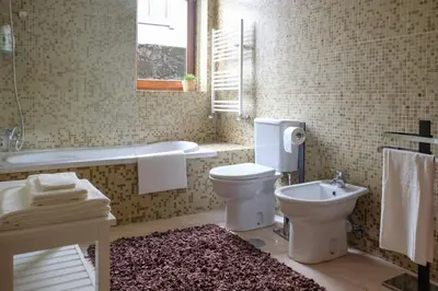 a bathroom with a toilet and a tub and a sink at Boavista Studio 99 & Garage in Porto