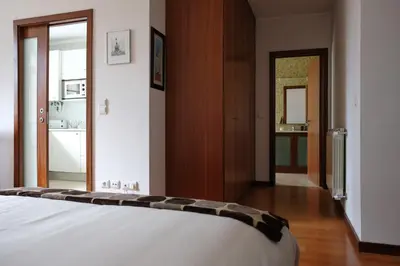 a bedroom with a white bed and a bathroom at Boavista Studio 99 & Garage in Porto