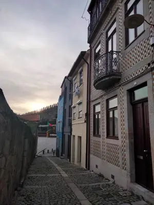 an alley with buildings and a balcony on a building at Dos Guindais - Turismo Urbano, Miradouro in Porto