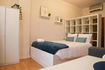 a bedroom with a large white bed with blue pillows at Bonsai Apartment II in Porto