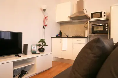 a living room with a couch and a tv and a kitchen at Bonsai Apartment II in Porto
