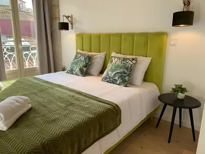 a bed with a green headboard in a room at Lost Inn Porto Hostel in Porto