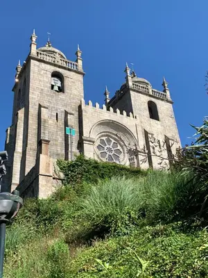 a large stone building with a clock tower on a hill at Lost Inn Porto Hostel in Porto