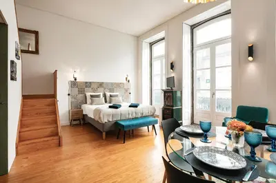 a bedroom with a bed and a dining room with a table at Duque Oporto Apartment in Porto
