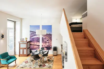 a living room with a staircase and a table and chairs at Duque Oporto Apartment in Porto