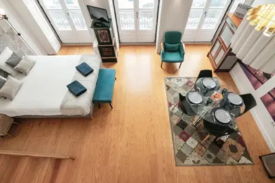 a living room with a bed and a table and chairs at Duque Oporto Apartment in Porto