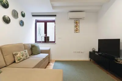 a living room with a couch and a flat screen tv at Douro by your side with Pool in Vila Nova de Gaia