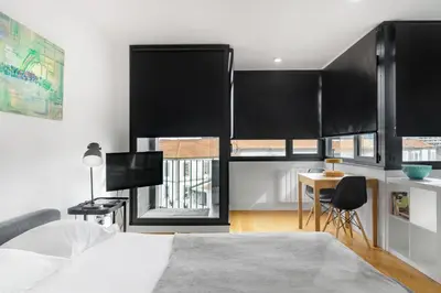 a bedroom with black curtains and a desk and a bed at B Porto Casa da Música in Porto