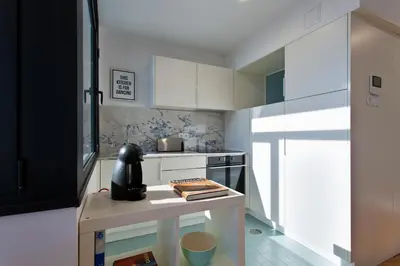 a small kitchen with white cabinets and a table at B Porto Casa da Música in Porto