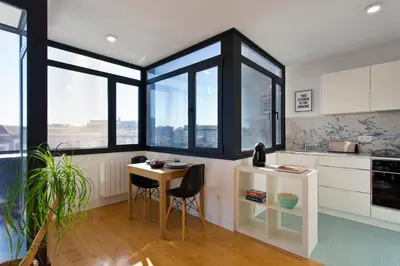 a kitchen with windows and a table and chairs at B Porto Casa da Música in Porto
