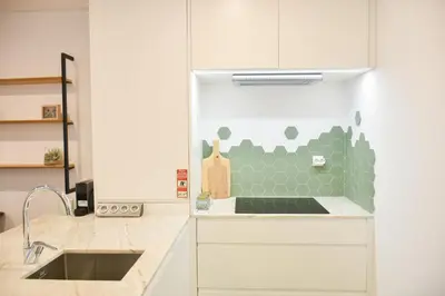 a kitchen with a sink and a green tile wall at Lindo apartamento 2 quartos com pátio - Batalha - APT C in Porto