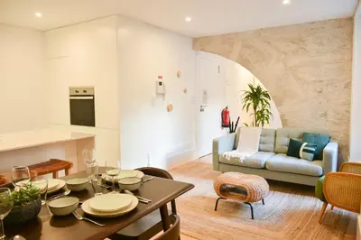 a living room with a table and a couch at Lindo apartamento 2 quartos com pátio - Batalha - APT C in Porto