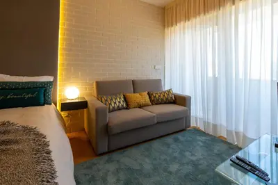 a living room with a couch and a window at Estúdio Encantador com vistas para o Douro Gaia in Vila Nova de Gaia