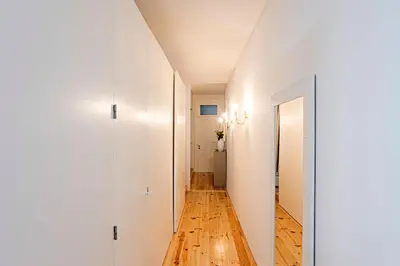 a hallway with white walls and a wooden floor at Lóios 1BR Flat Downtown by LovelyStay in Porto