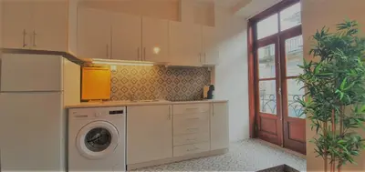 a kitchen with a washing machine and a washer at Clérigos City Heart Flat in Porto