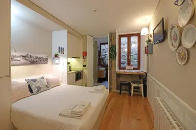 a bedroom with a large bed and a bathroom at FLH Porto Ribeira Typical Studio in Porto