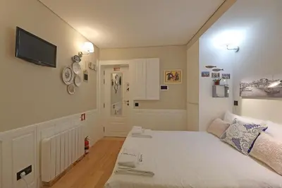 a bedroom with a bed and a tv on the wall at FLH Porto Ribeira Typical Studio in Porto