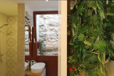 a bathroom with a wall covered in plants at FLH Porto Ribeira Typical Studio in Porto