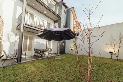 a patio with an umbrella and a table and chairs at OPORTO GUEST Lotte House in Porto
