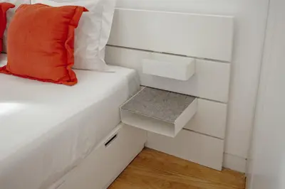 a white bed with an orange pillow on it at OPORTO GUEST Lotte House in Porto