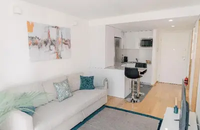 a white living room with a couch and a kitchen at Oporto Yellow Apartments in Porto