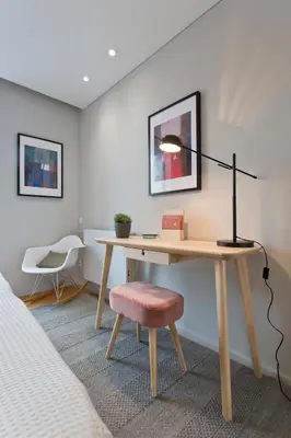 a desk with a lamp and a chair in a room at Balconies of Cedofeita & Garage in Porto