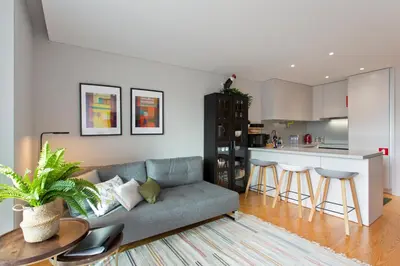a living room with a couch and a kitchen at Balconies of Cedofeita & Garage in Porto