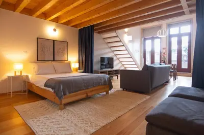 a bedroom with a bed and a living room at Batalha Garden Apartment in Porto