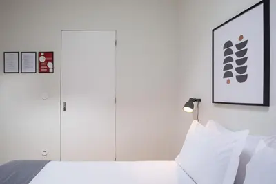 a white bedroom with a bed with white pillows at Batalha Garden Apartment in Porto