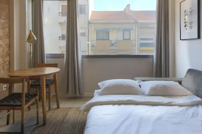 a bedroom with a bed and a table and a window at Marquês Deluxe Apartments 3 & 4 in Porto
