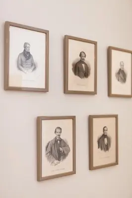 a group of framed photographs of men on a wall at VIVA Whilom Secret with garage in Porto