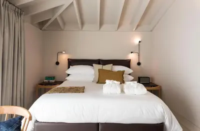 a hotel room with a bed and a table and a desk at Jardins do Porto - by Unlock Hotels in Porto
