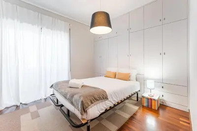 a bedroom with a bed and a large window at GuestReady - Warwick avenue in Lapa in Porto