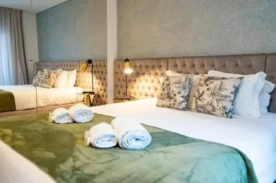 a hotel room with two beds with towels on them at N&N Home in Porto