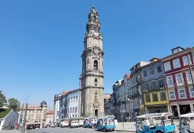 a tall clock tower in a city with buses at N&N Home in Porto