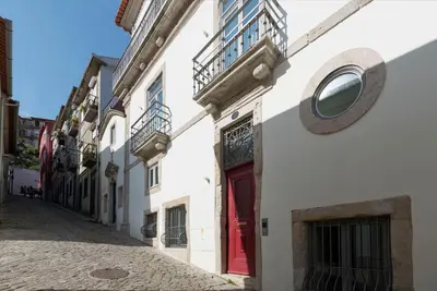 a white building with a red door on a street at Classy & Stylish Porto Duplex in Porto
