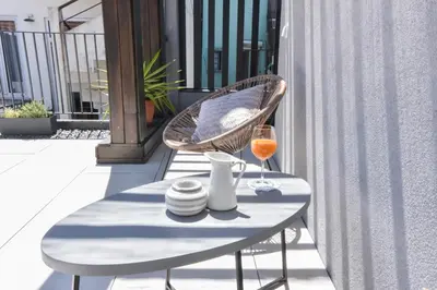 a table with a glass of wine on a balcony at Oporto lovely house deluxe in Porto