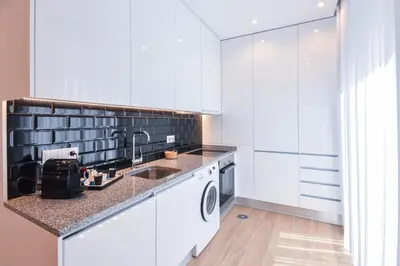 a white kitchen with a sink and a dishwasher at Oporto lovely house deluxe in Porto