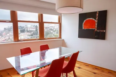 a dining room with a glass table and red chairs at Citybreak-apartments Douro View in Porto