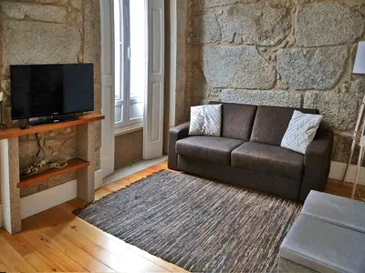 a living room with a couch and a tv at Citybreak-apartments Bolhao in Porto