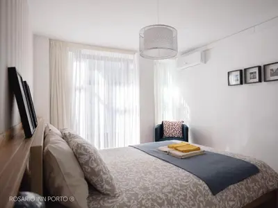 a bedroom with a bed and a window at rosario inn porto in Porto