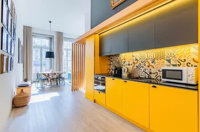 a kitchen with yellow cabinets and a table in it at Porto Legend Apartments in Porto